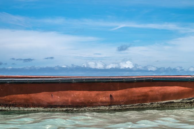 Side of red boat in tropical waters