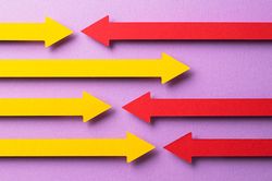 Yellow and pink paper arrows going in opposite directions