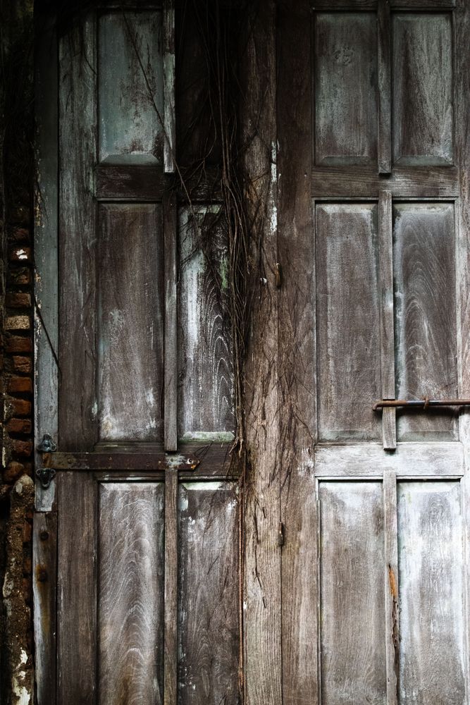 Big old broken wooden door on brick wall of historical building located in Kota Lama, Semarang City, Indonesia.