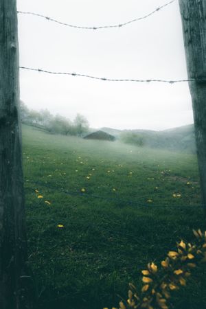 View of hazed landscape through fence with wire