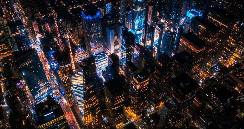 Top Down Aerial View of New York City Streets in Manhattan at Night. Helicopter Flying Along a Straight Endless Avenue Road with Cars, Taxis, Busses and Other Transportation