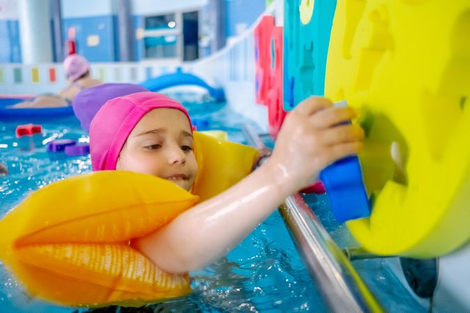 girl with water wings in swimming pool