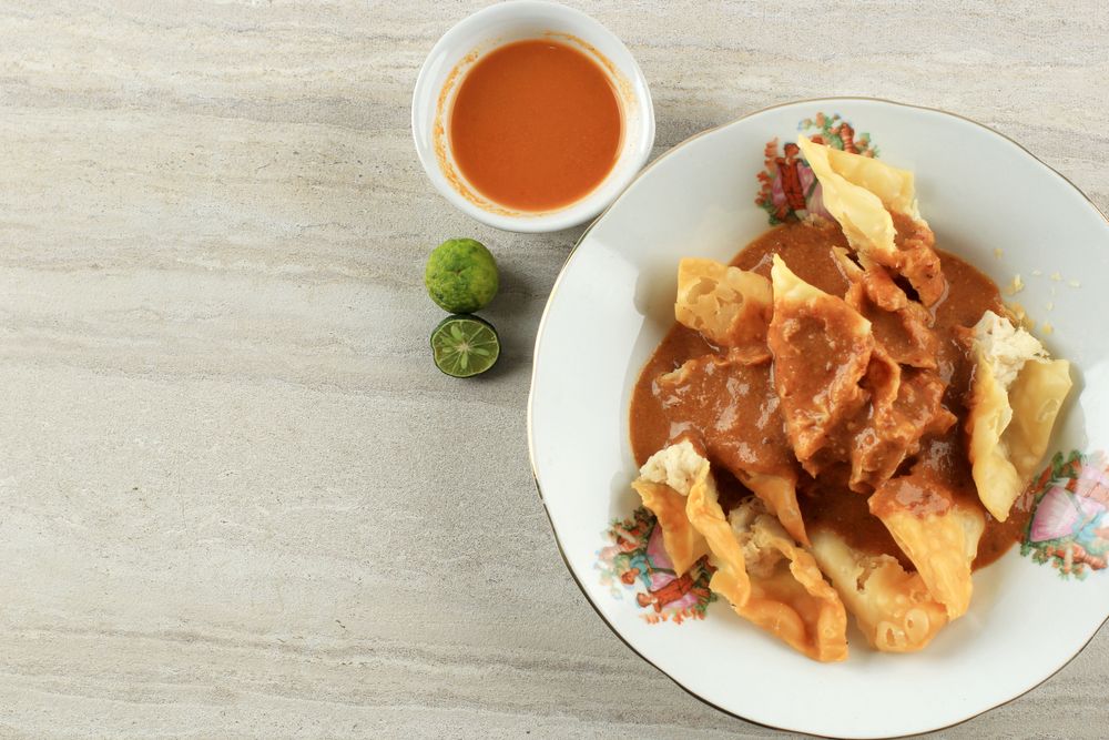 Top view of deep fried fish dumplings with peanut sauce and copy space