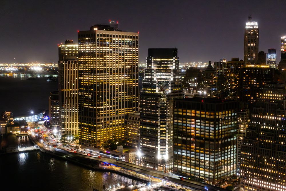 Aerial View of New York City at Night. Helicopter Shot of a Busy Highway Around Manhattan. Panoramic View with Traffic Around a Big City with Skyscrapers in the Background