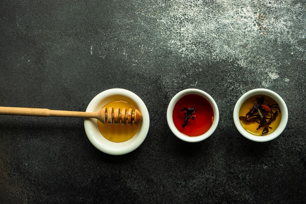 Top view of honey and two cups of teas