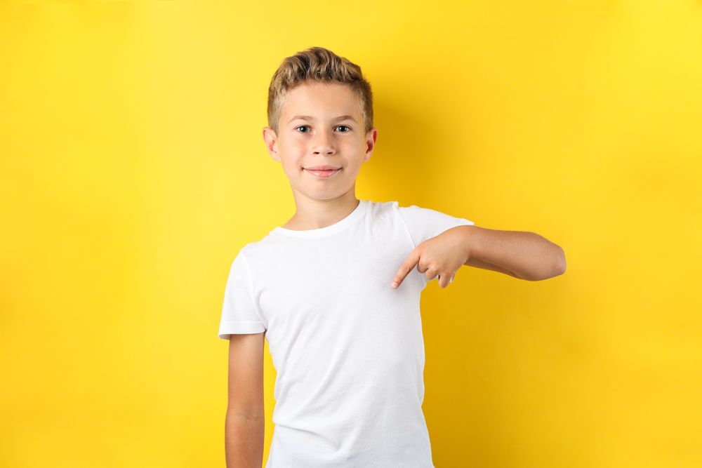 Boy in t-shirt against yellow background, space for text