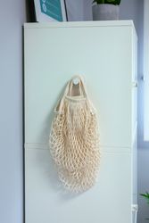 Reusable mesh shopping bag hanging on side of wardrobe