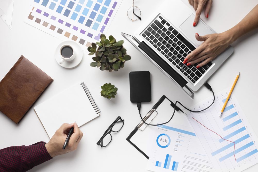 Arrangement of office elements with two people on light desk