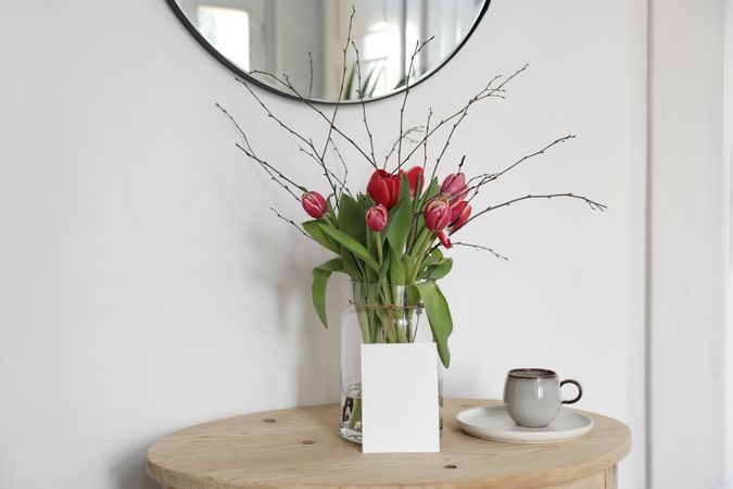 Vase of tulips on entry way table with mockup paper card