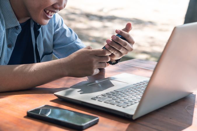 Close Up Asian Young businessman work at outdoor with laptop. Concept of remote and freelance work. Young successful man wearing casual blue cloth.