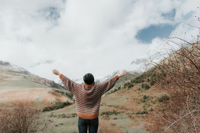 Young woman standing in a beautiful landscape between mountains