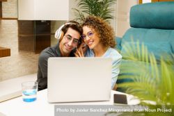 Happy couple using laptop on coffee table at home 4jV7OJ