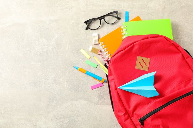 Flat lay composition with backpack and school supplies on grey background