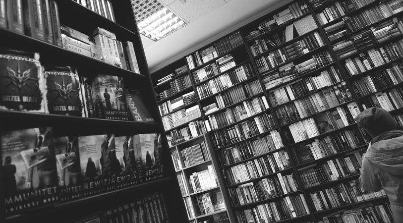 Grayscale photo of bookshelves in library