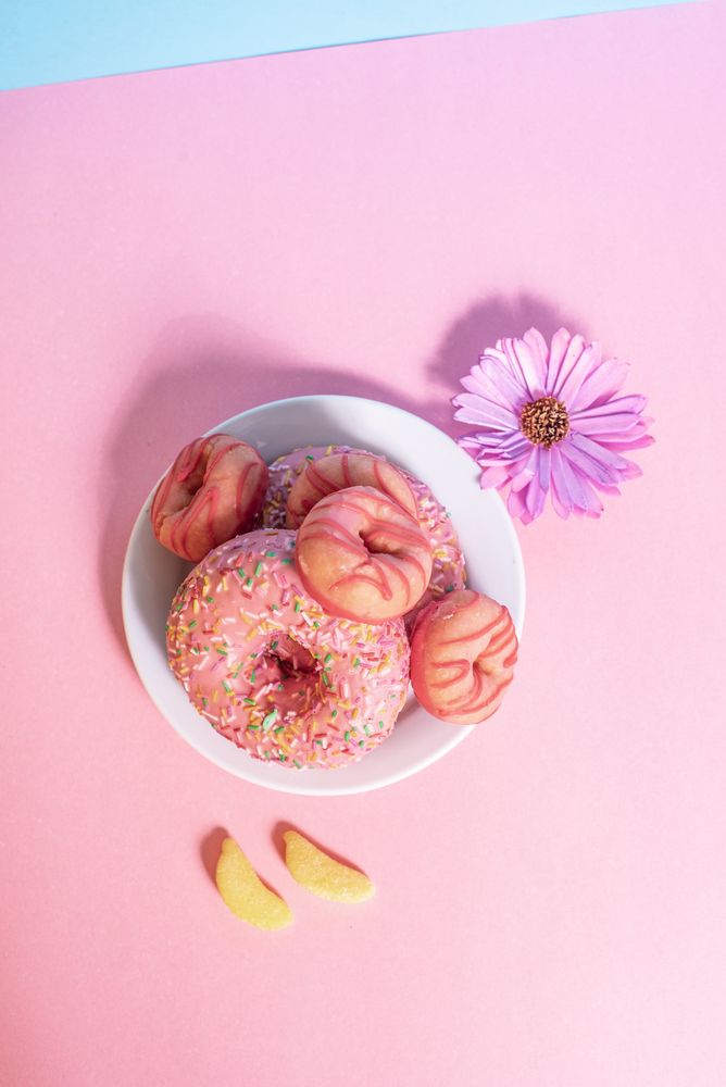 Pink doughnuts with banana shape candies and flower
