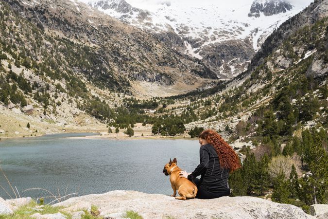 Traveling woman with dog in mountains