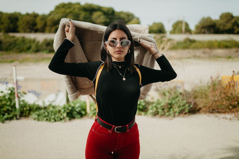 Stylish woman with jacket on beach