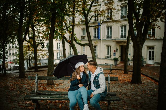 Happy couple sitting on bench in city street