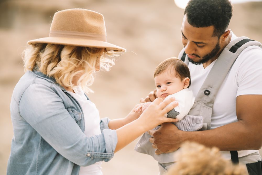 Diverse parents dancing while standing with baby