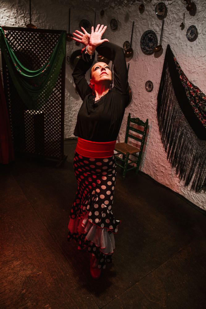 Woman dancer in flamenco costume standing in dance posture