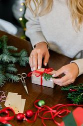 Woman making beautiful Christmas gift at table