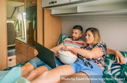 Male and female enjoying a film on a digital tablet on a motorhome bed 47ARk0