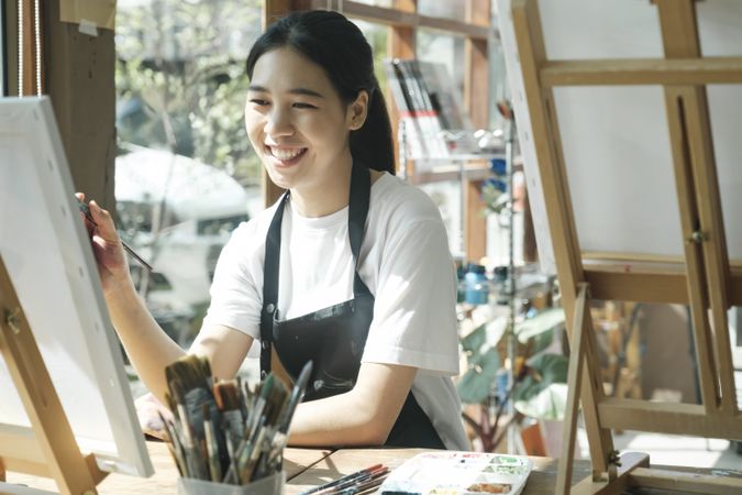 Crafting Inspiration. Female Artist Sketching and Painting in Workshop