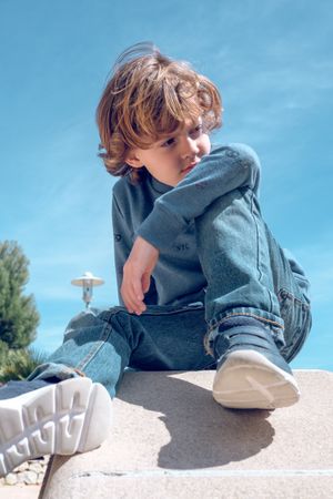 Boy sitting on rock in nature