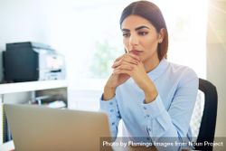 Woman looking somberly at computer while thinking about a problem 5q7Xob