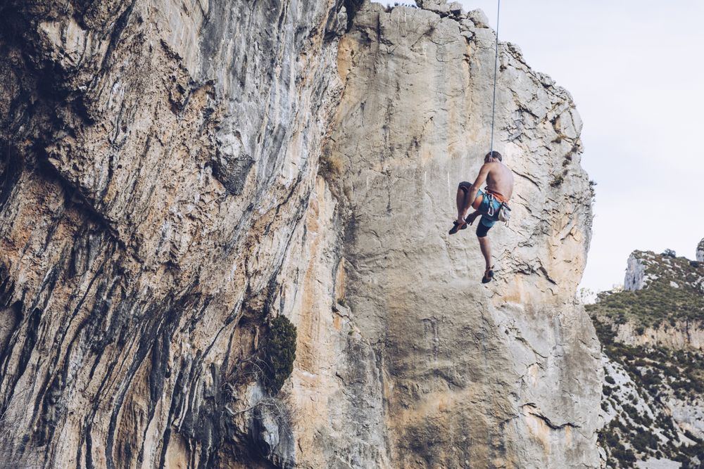 Anonymous climber handing on cliff