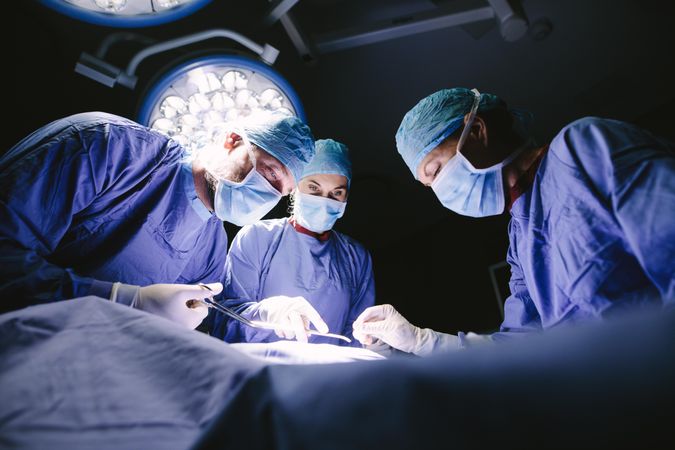 Group of surgeons doing surgery in hospital operating theater