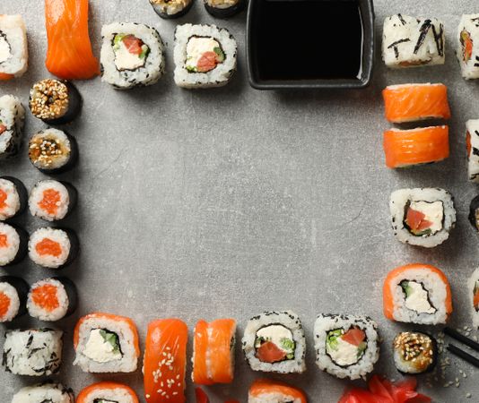 Flat lay with sushi rolls on gray background, space for text
