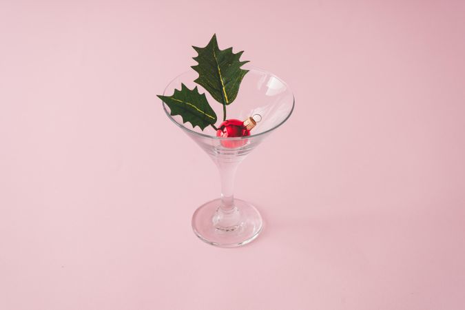 Christmas tree decoration in martini glass on pastel pink background with creative copy space