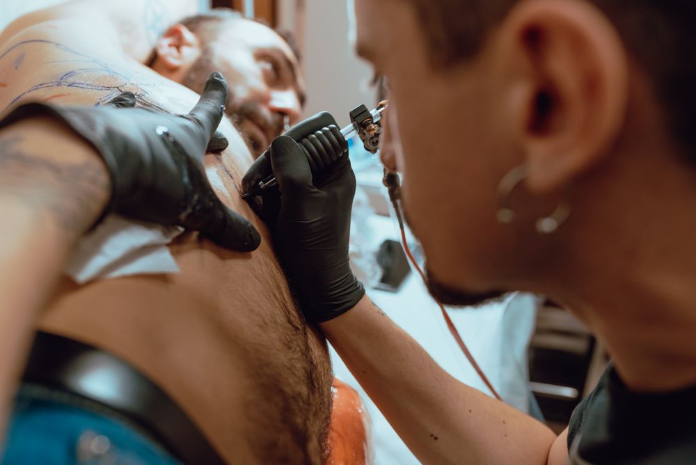 Stylish man receiving tattoo