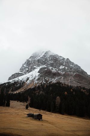 Lonely house in field by mountain