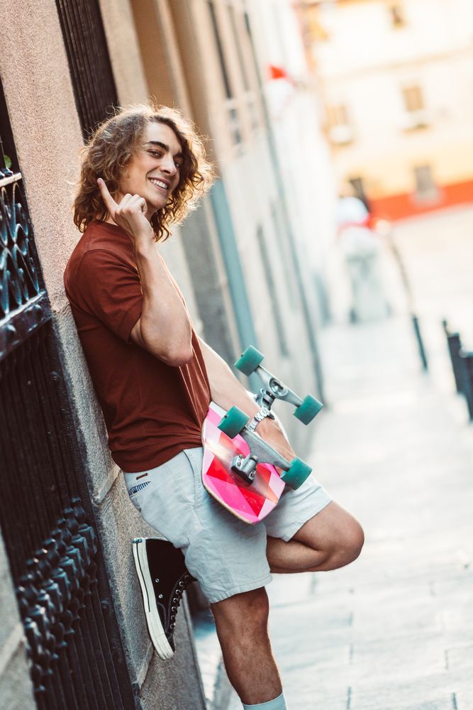Man carrying longboard on the street