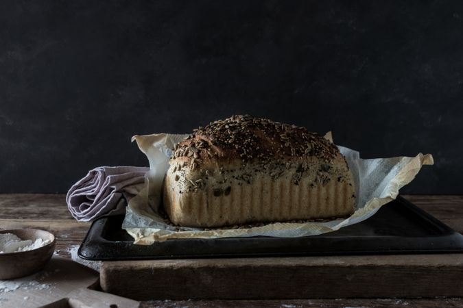 Fresh bread with wheat grains on tray