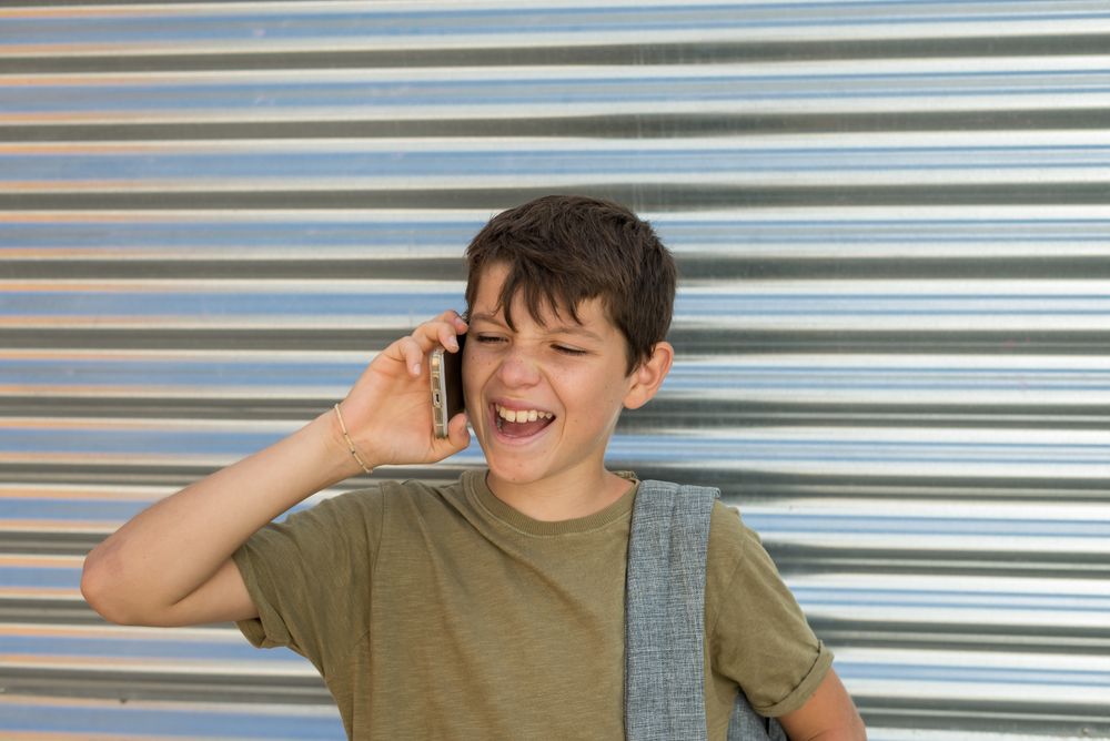 Teenage male having funny conversation in front of shutter