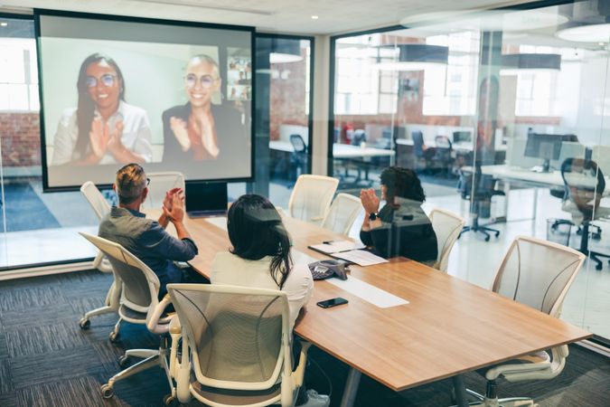 Creative businesspeople clapping during a video conference