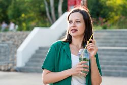 Woman drink soft drink on walk in park