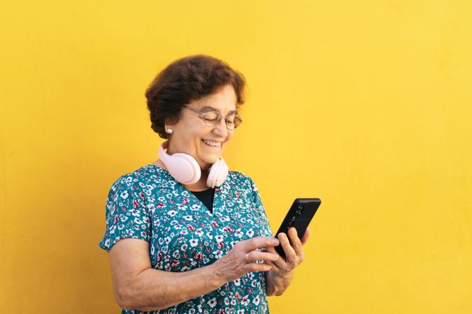 Smiling older woman using smartphone outdoors