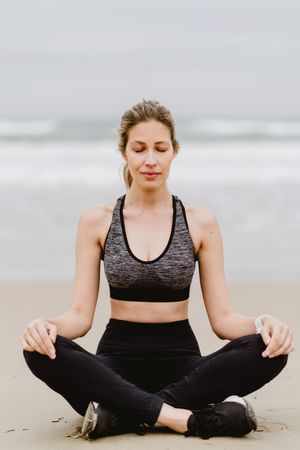 Woman meditating on the beach