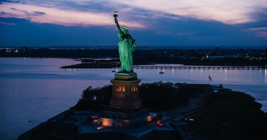 Aerial Image of the Statue of Liberty. Helicopter Shot of the Patriotic Monument in Beautiful Sunset Setting, Standing on a Liberty Island in New York City Harbor