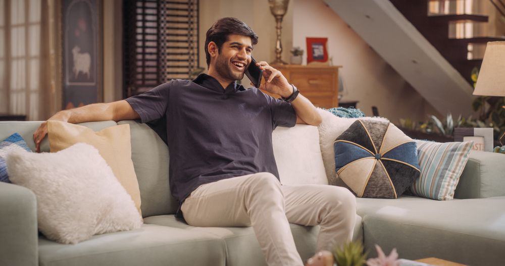 Indian Man Making Important Phone Call at Home, Balancing Remote Work and Personal Life.