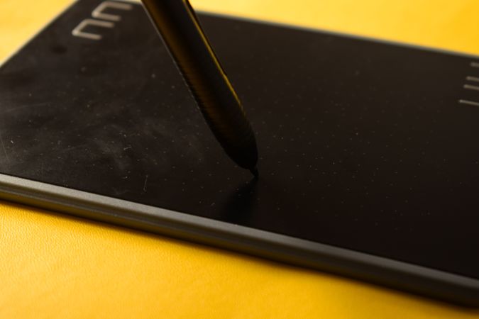 Close up of digital tablet and stylus on yellow table