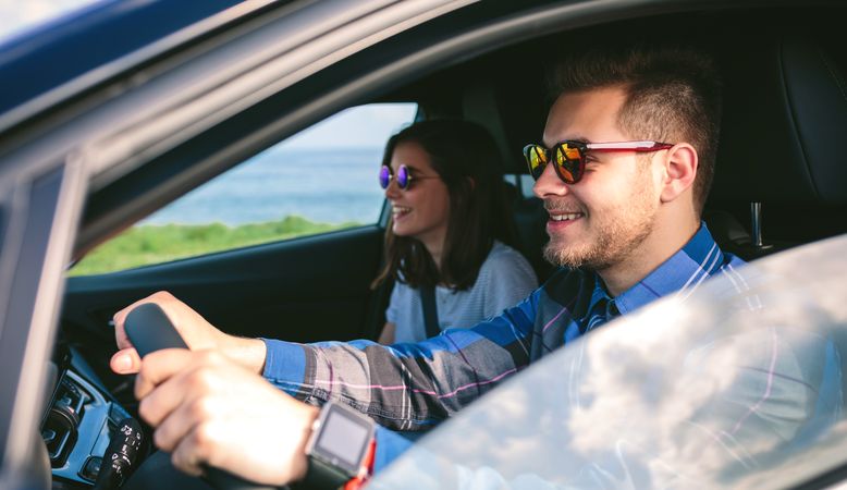 Young man driving a car with his girlfriend