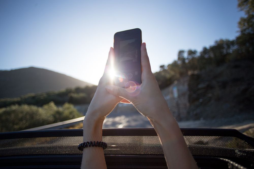 POV of smart phone taking a picture out of a car’s sunroof