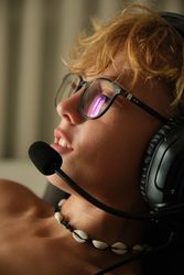 Crop young man in headphones and glasses sitting on a chair