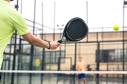 Back view of a man playing paddle tennis