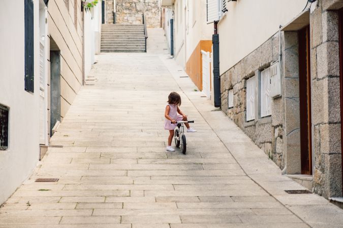 Girl riding on bicycle in narrow street
